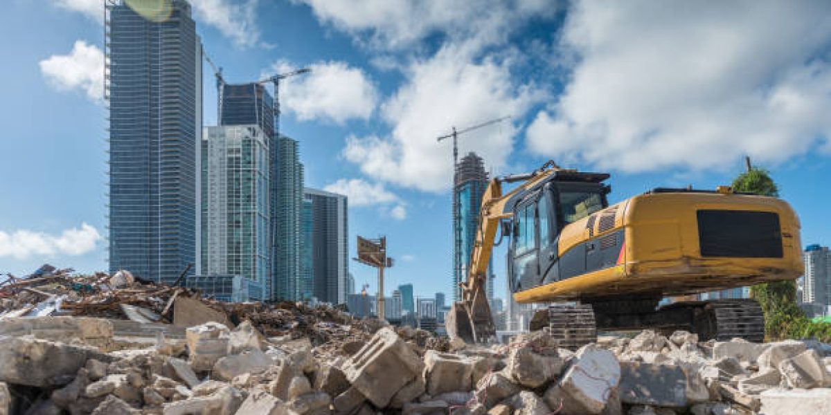 Heavy machinery cleaning a rubble site for a new housing development site in Miami.